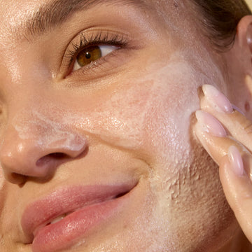 Woman cleansing her face with vegan cleanser